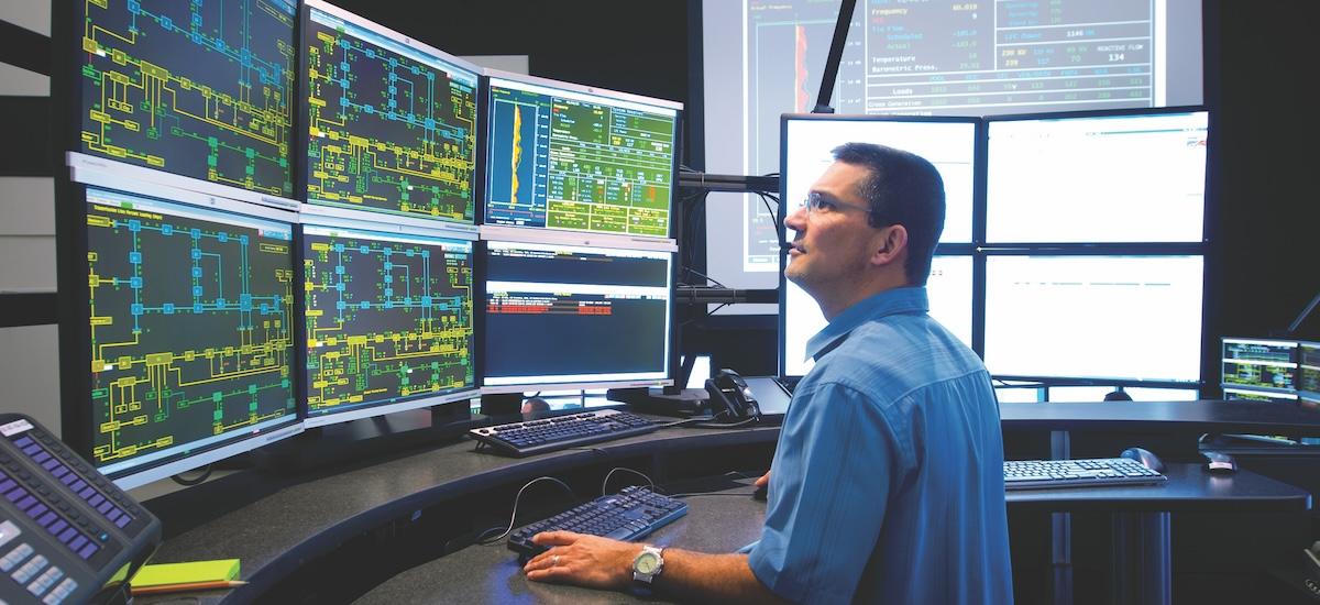 Man sitting in front of screens in a control center