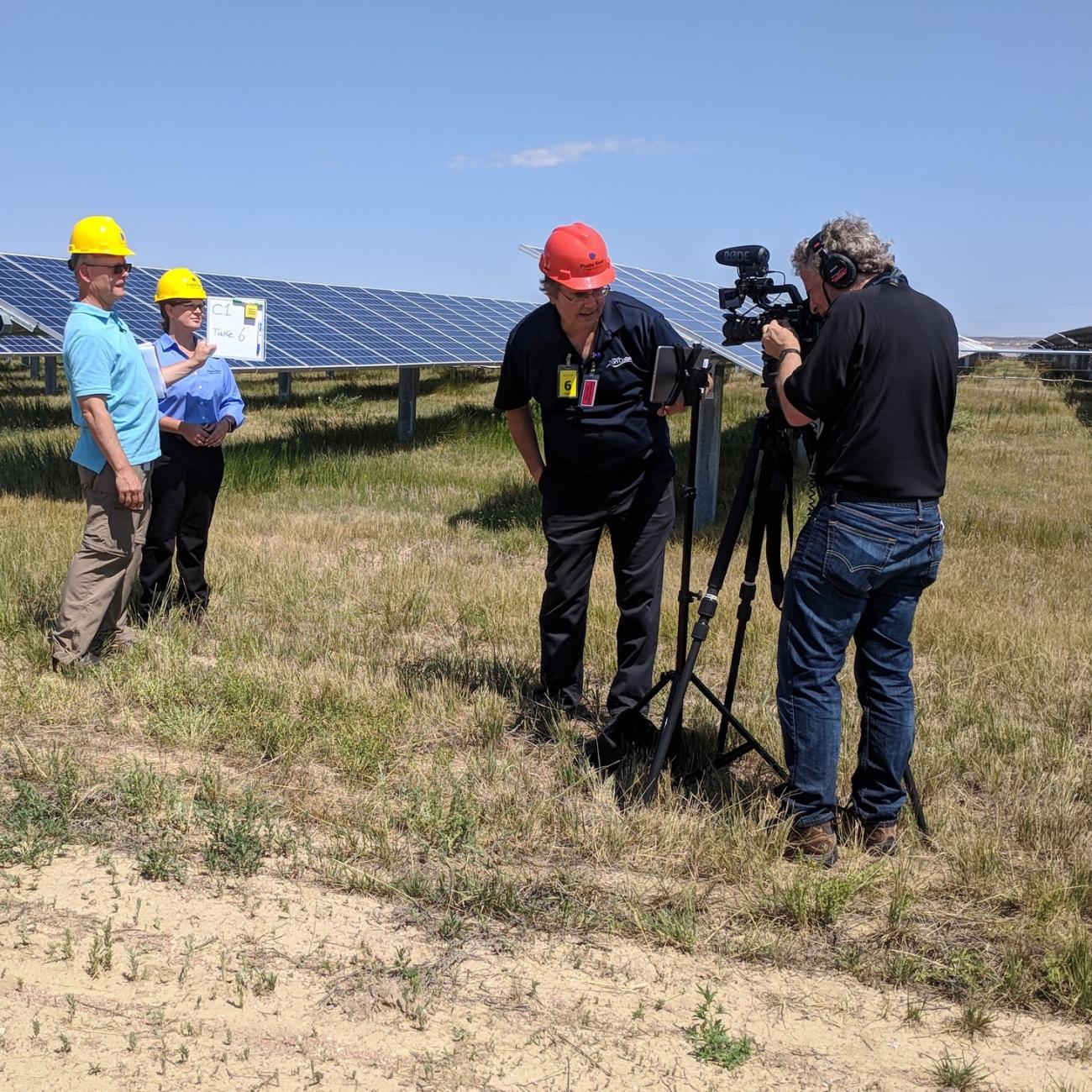 Crew shooting a video in front of solar array