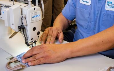 A worker with Los Angeles Department of Water and Power sews a cloth mask