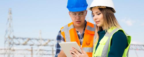 utility workers looking at a tablet