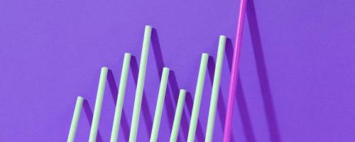 series of round rods leaning against a purple wall